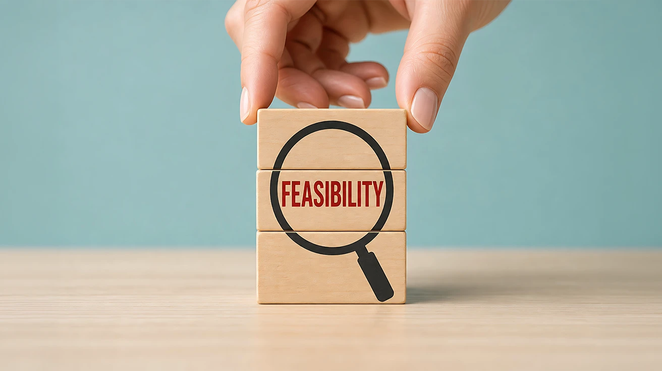 Market Research Feasibility Study concept with magnifying glass highlighting feasibility on wooden blocks