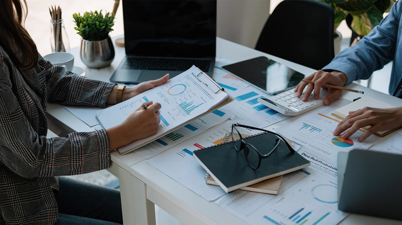 New Business Market Research team reviewing charts, reports and business data during a meeting.