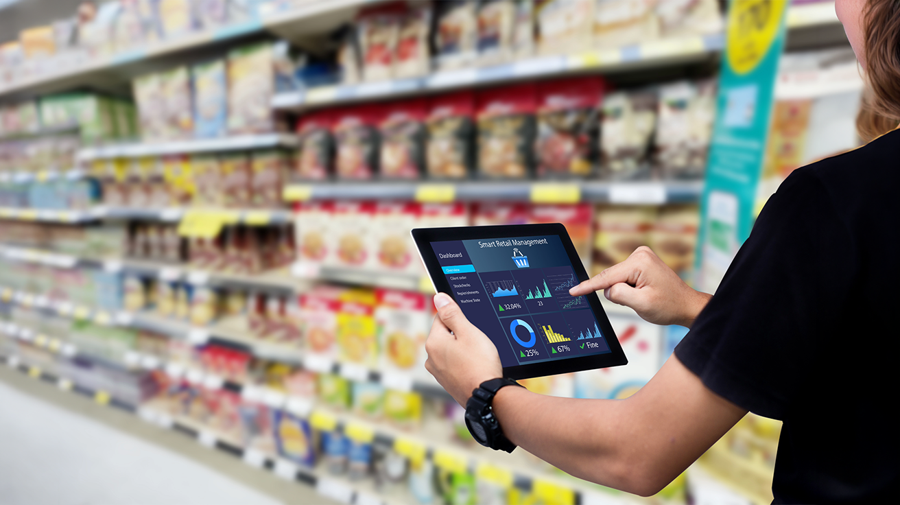 Retail Audit Services expert reviewing store shelves and analysing product performance using a digital tablet